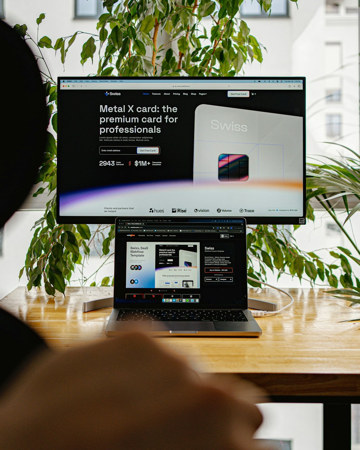 Projektant pracuje nad laptopem i monitorem nad projektem strony internetowej.